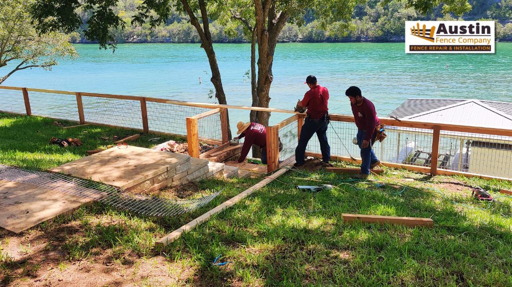 men installing fence near lake