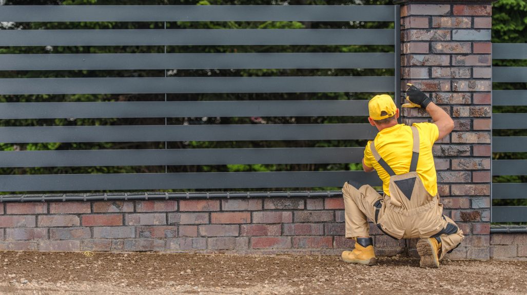 person inspecting metal fence