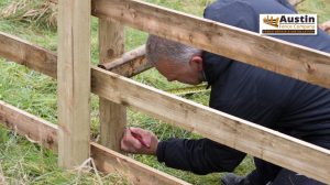 person fixing wooden fence